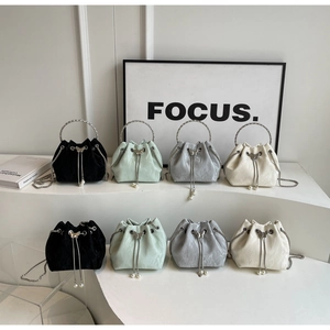 Détail de sacs seaux de luxe avec poignées en anneau, breloques papillon et perles