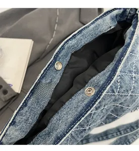 Vista dettagliata del tessuto denim blu trapuntato con bottoni a pressione in metallo