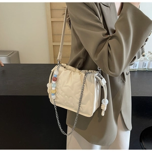 Détail du sac seau crème avec motifs d'étoiles et de lapins matelassés et chaîne en métal