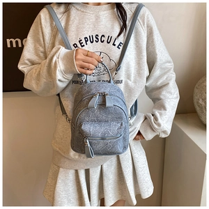 Detail of light blue mini backpack with marble texture and slim shoulder straps