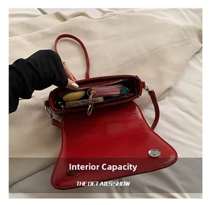 Internal view of red leather crossbody bag showing daily essentials and silver snap