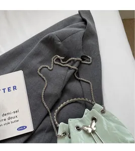 Détail du sac seau vert menthe avec boucle papillon et poignée en anneau métallique