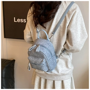 Rear view of a light blue mini backpack with marble texture on a model's back