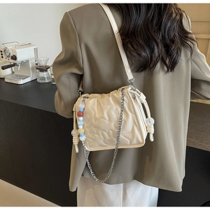 Détail du sac matelassé crème avec gaufrage d'étoiles et perles colorées