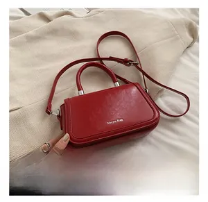 Close-up of red vegan leather crossbody bag with lychee texture and silver hardware