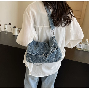 Dettaglio della borsa tote in denim trapuntato con catena argento indossata