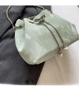 Détail du sac seau vert menthe avec breloques perles et texture chatoyante d'ondulations