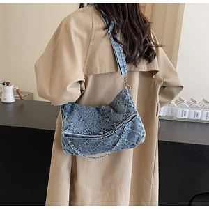 Dettaglio della borsa tote in denim con trapuntatura a rombi e catena argento sul retro
