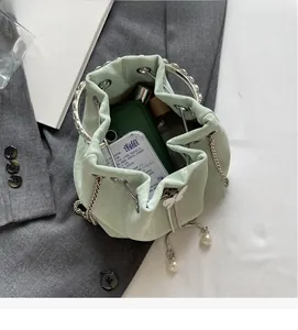 Détail de l'intérieur spacieux d'un sac seau vert menthe avec chaîne et poignée perlée