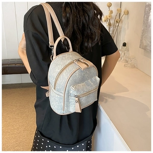 Rear view of a model wearing a mini marble-patterned backpack with cream leather trim