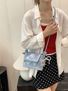 Light blue crossbody bucket bag with pearl bow and rope strap on model