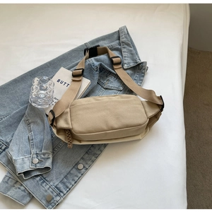 Detailansicht der khakifarbenen Segeltuch-Brusttasche mit Schnalle auf einer Jeansjacke