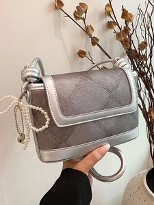 Silver-grey quilted denim bucket bag with pearl chain and stylish knotted strap