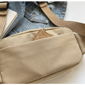 Nahaufnahme der Canvas-Umhängetasche mit Vordertasche und gesteppter Geldbörse