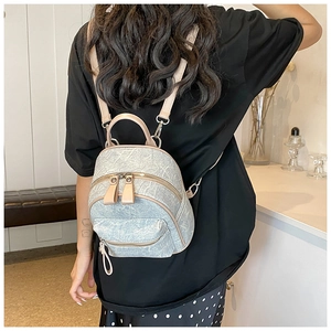 Mini backpack with marble texture and beige leather straps shown on a model back