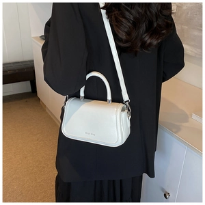 Détail d'un sac à bandoulière blanc avec ferrures argentées et une poignée supérieure
