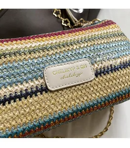Close-up of colorful striped woven straw bag with gold chain and leather logo tag