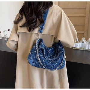 Borsa tote in denim blu con trapuntatura a rombi e tracolla a catena in un caffè urbano