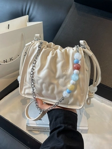 Sac seau beige avec cordon de serrage, motifs d'étoiles et bandoulière en perles colorées