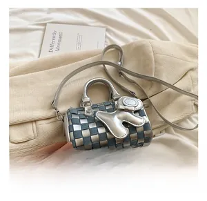 Detail view of woven checkered mini pillow bag with silver leather rabbit charm