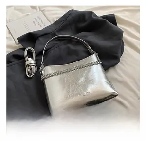 Détails du sac argenté brillant avec chaîne métallique et bandoulière réglable