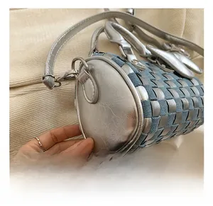 Detail shot of the woven metallic silver and denim pillow bag with round silver handle