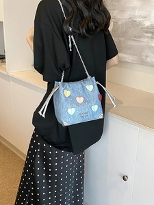 Light blue denim bucket bag with colorful heart patches and silver chain strap