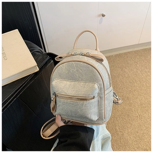 Detail of mini grey backpack featuring a cute bow and premium faux leather texture