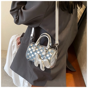 Detail of checkered denim and silver mini Boston bag with cute dog charm on model