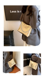 Détail du sac à chaîne doré métallisé avec grosse chaîne argentée porté par le mannequin