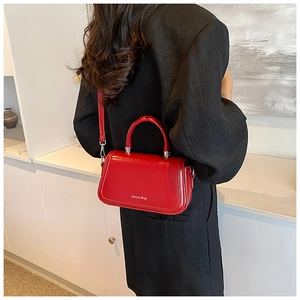 Détail du sac bandoulière rouge brillant avec ferrures argentées et logo Shiyu Bag