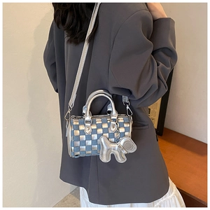 Detail of blue and silver checkered mini barrel bag with silver puppy charm and metal handle