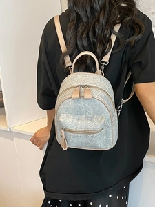 Mini light blue marble pattern backpack with beige leather straps shown on a model