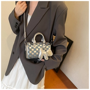 Detail of checkered barrel bag with silver metallic finish and denim puppy charm