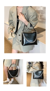Détail d'un sac à bandoulière en cuir noir brillant avec chaîne en métal argenté