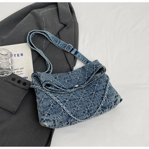 Dettaglio della borsa in denim trapuntato con catena in metallo e tracolla regolabile