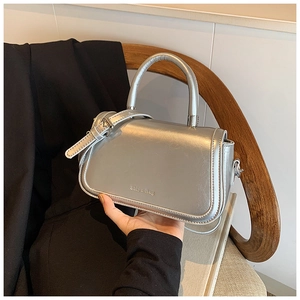 Détail du petit sac argenté métallisé avec logo Shiyu-Bag et poignée rigide