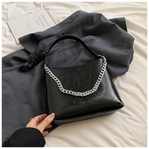 Détail du sac à main noir en similicuir plissé avec finition brillante et chaîne argentée