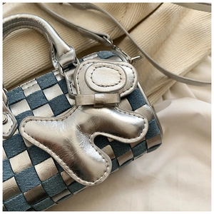 Close-up of metallic silver and denim checkerboard pillow bag with a dog motif