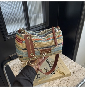 Detail of colorful woven straw pillow bag with leather handle and gold floral chain