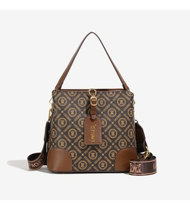 Close-up of brown monogram bucket bag with leather details and wide jacquard strap