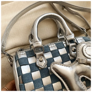 Detail of blue denim and silver metallic woven checkerboard pillow bag with star charm