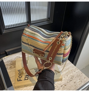 Detail of bohemian woven barrel bag featuring colorful zigzag patterns and gold chain