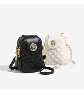 Detail gesteppter Handytaschen in Schwarz und Beige mit goldenen Metallelementen