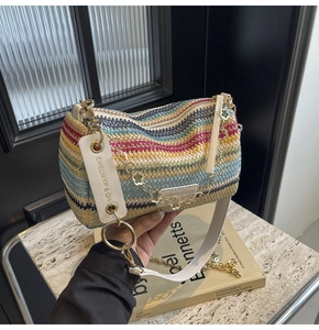 Detail of multi-color woven cylinder bag with leather trim and gold petal chain