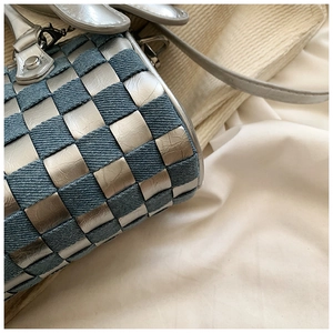 Detailed macro shot of the silver woven leather and blue denim checkerboard pattern bag