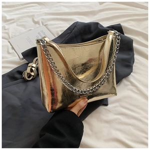 Détail du sac à chaîne doré métallisé avec texture plissée vintage et bandoulière