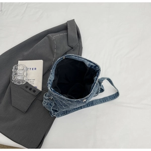 Dettagli interni di una borsa tote in denim trapuntato blu con tracolla a catena