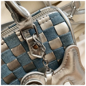 Detail of blue denim and silver leather checkered weave with a metallic puppy charm