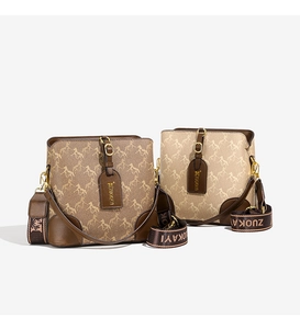 Detail of trendy bucket bag with horse pattern and branded wide fabric shoulder strap